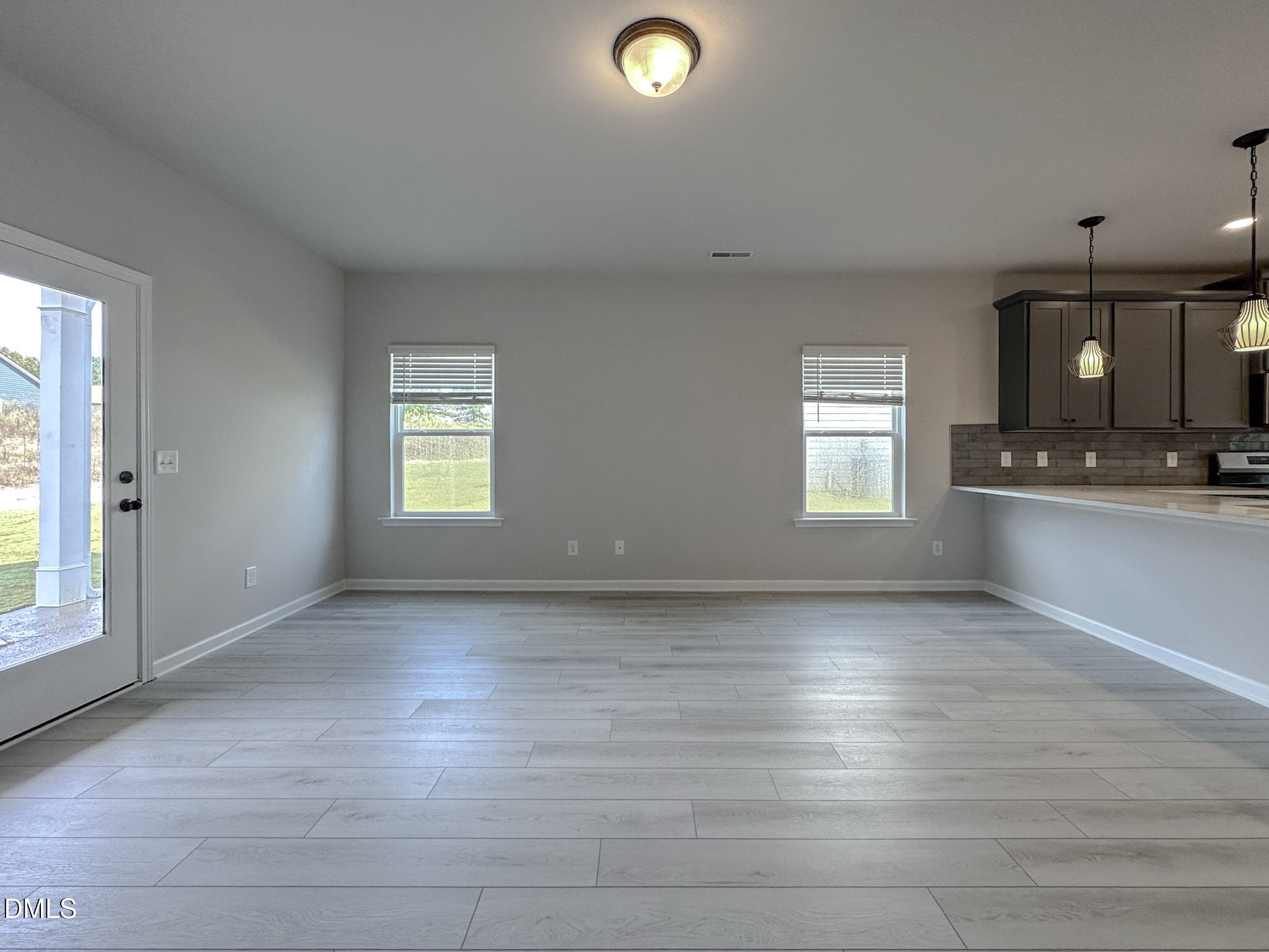 337 White Azalea Way Benson, NC 27504 - Photo 14 of 35 an empty room with wooden floor and windows