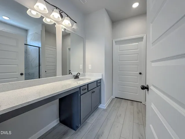 a bathroom with a sink a large mirror and shower