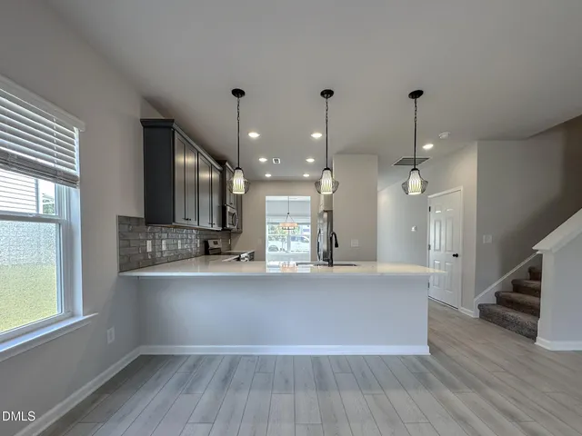 a large white kitchen with wooden floors and a fireplace