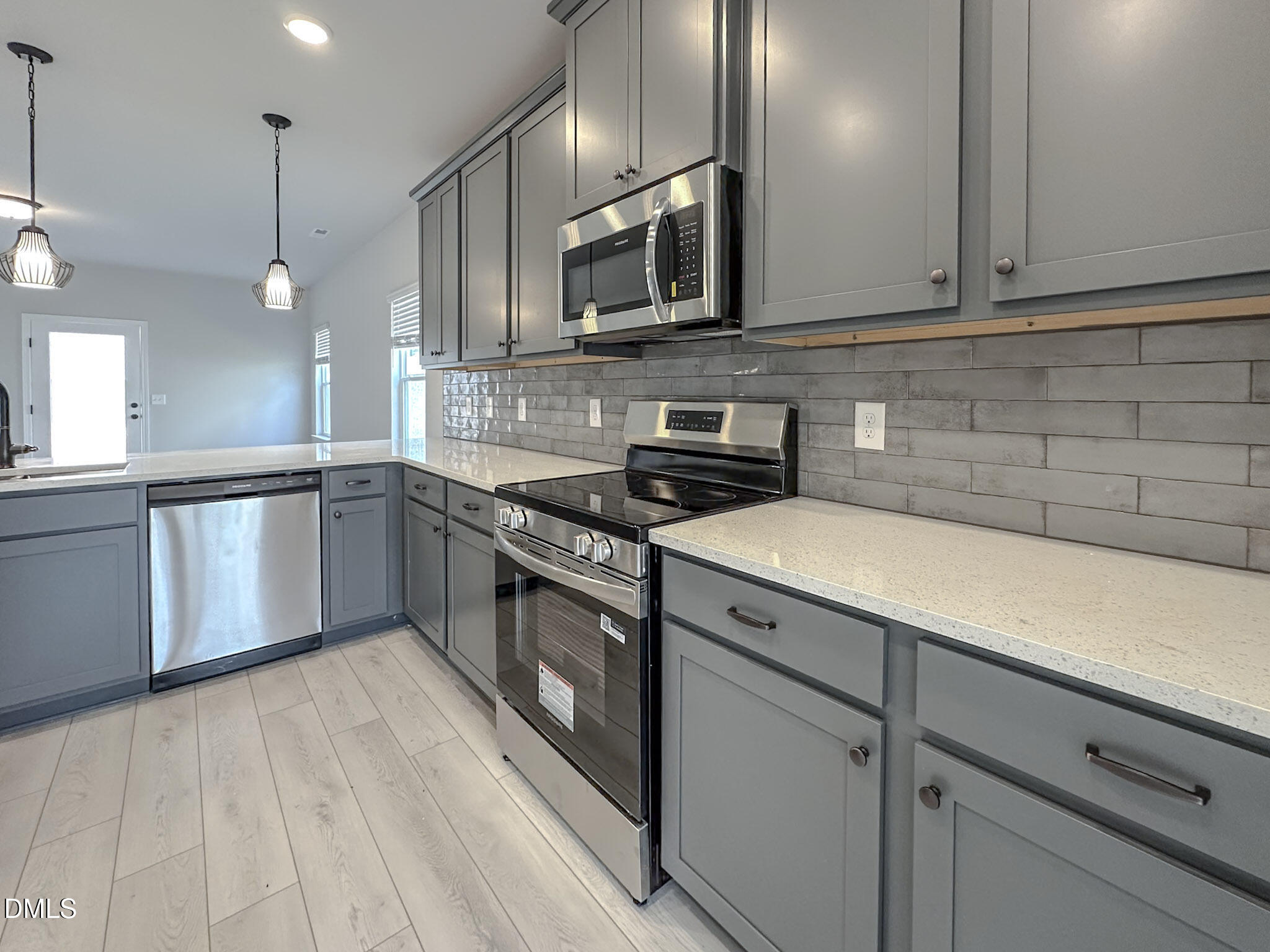 337 White Azalea Way Benson, NC 27504 - Photo 9 of 35 a kitchen with stainless steel appliances granite countertop a sink a stove and a microwave oven