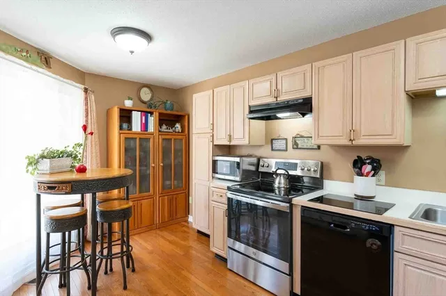 a kitchen with stainless steel appliances a stove refrigerator sink and cabinets