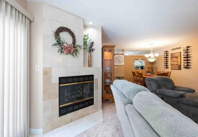 a living room with furniture a fireplace and a large window