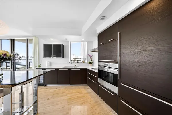 a large kitchen with kitchen island granite countertop a stove and a sink