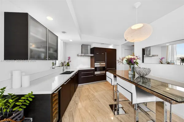 a kitchen with kitchen island a counter top space a sink and cabinets