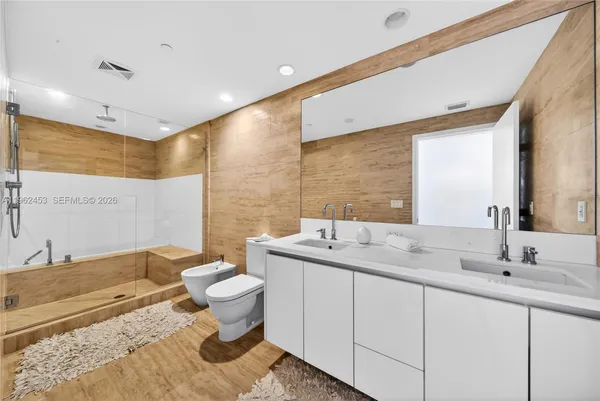 a bathroom with a double vanity sink toilet and a mirror