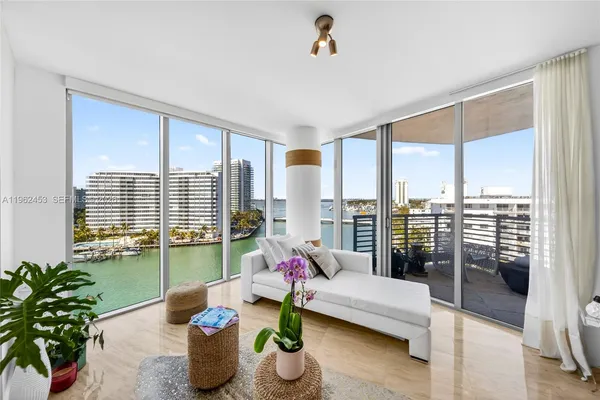 a living room with furniture and floor to ceiling windows