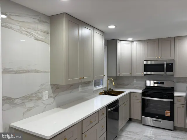 a kitchen with stainless steel appliances granite countertop a sink and a stove