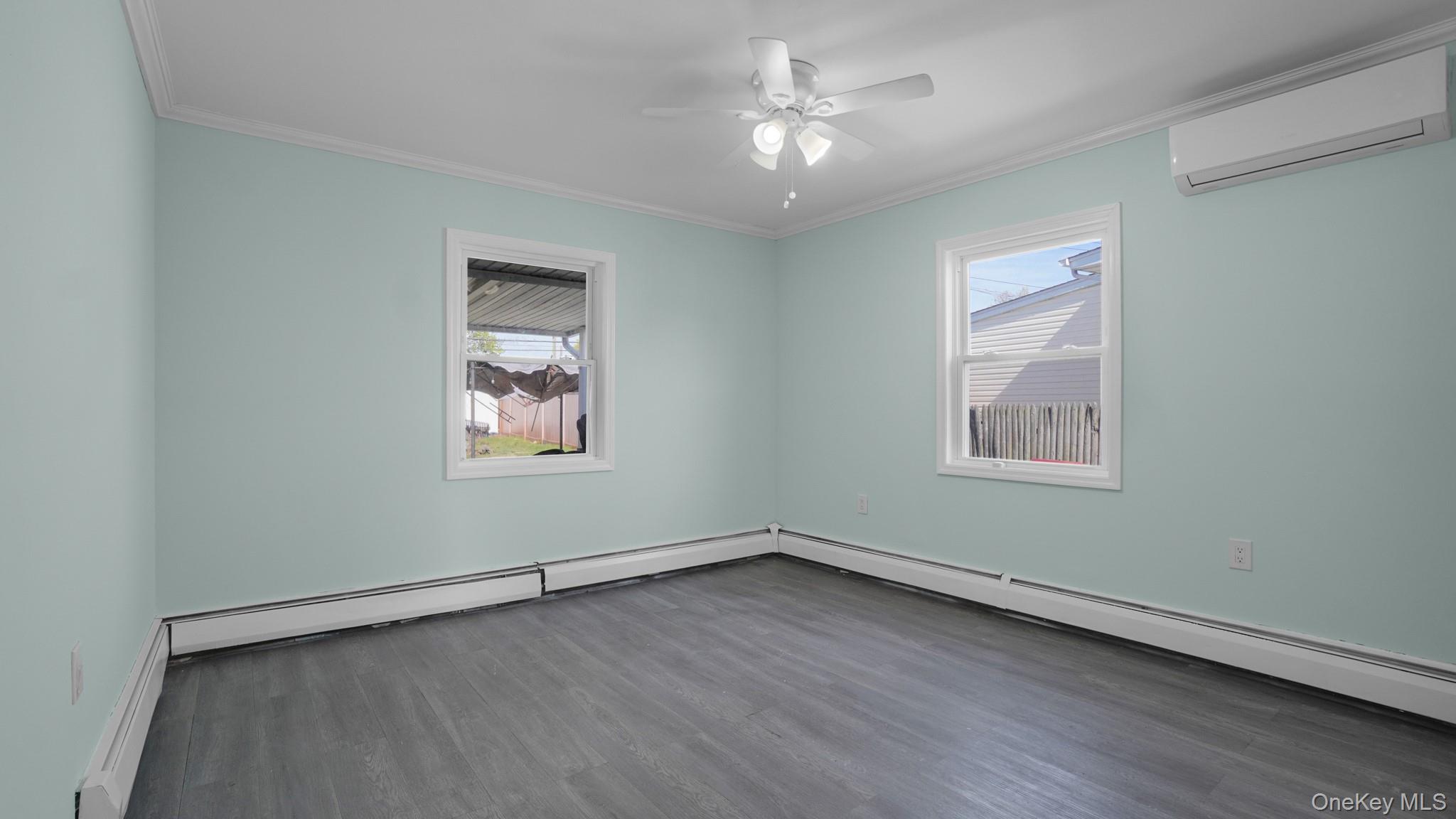 63 Blacksmith Road Levittown, NY 11756 - Photo 15 of 25 Interior room featuring wood-finish flooring, light blue painted walls, and white crown molding