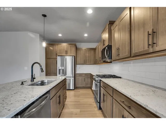 a kitchen with a sink stainless steel appliances and cabinets