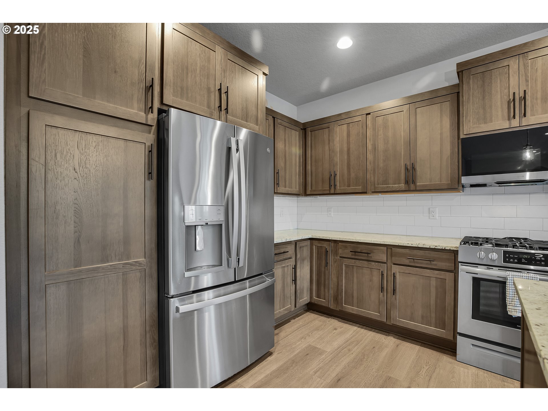 38249 Mulberry Street Sandy, OR 97055 - Photo 21 of 44 a kitchen with stainless steel appliances granite countertop a refrigerator a stove and a sink with wooden cabinets