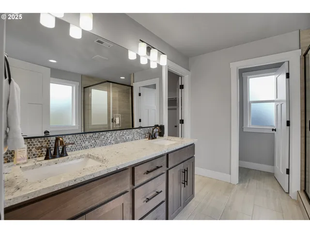 a bathroom with a double vanity sink and a mirror