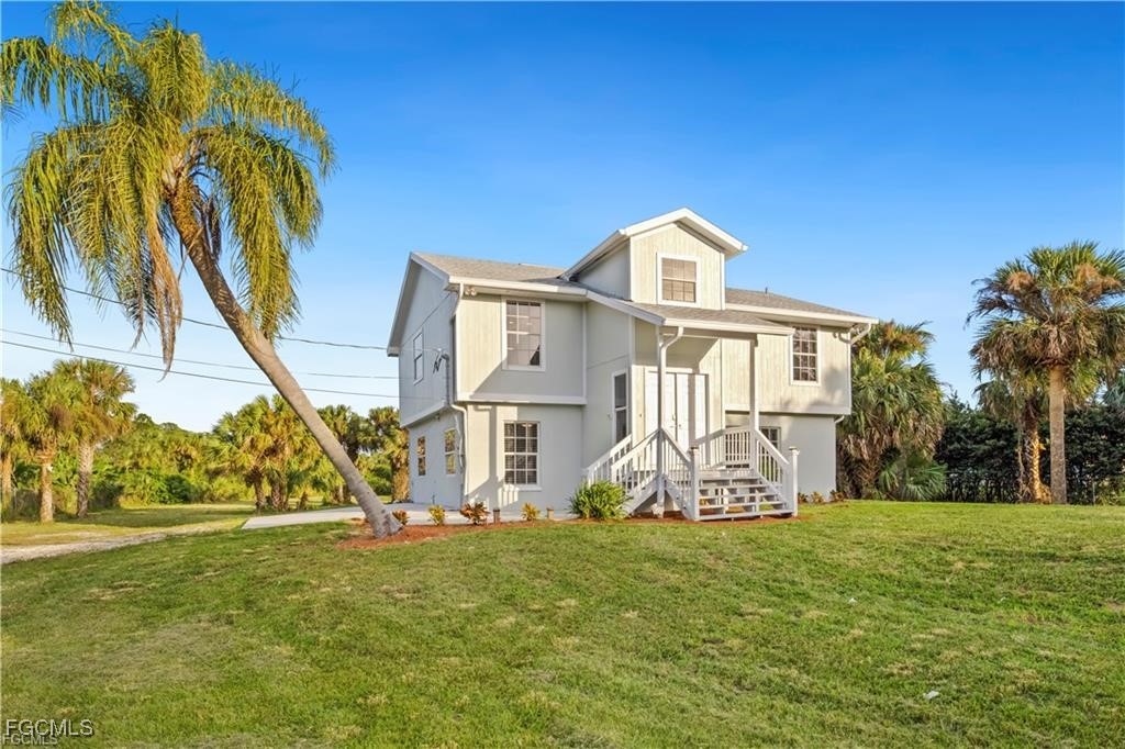 260 13th Street Southwest Naples, FL 34117 - Photo 1 of 13 a front view of a house with garden