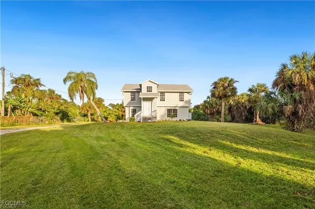 a view of a big yard with a house in the background