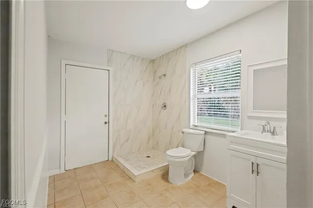 a kitchen with granite countertop a stove a sink and a refrigerator