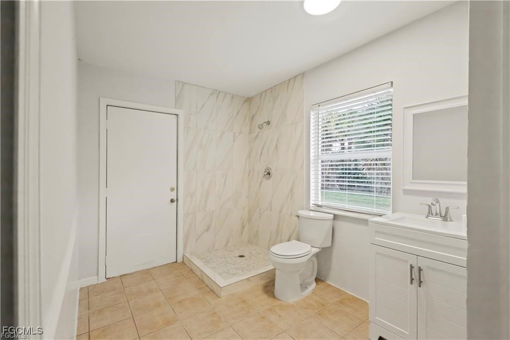 260 13th Street Southwest Naples, FL 34117 - Photo 9 of 13 a bathroom with a toilet sink a shower and a window