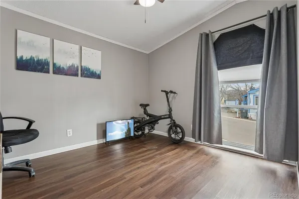 a view of a workspace with wooden floor and a window