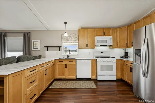 a kitchen with granite countertop a sink stainless steel appliances and white cabinets