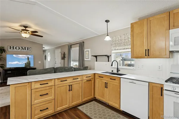 a kitchen with kitchen island granite countertop a sink stainless steel appliances and cabinets