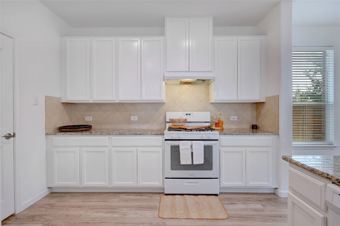 468 Sheepshank Drive Georgetown, TX 78633 - Photo 11 of 27 a kitchen with a stove and white cabinets