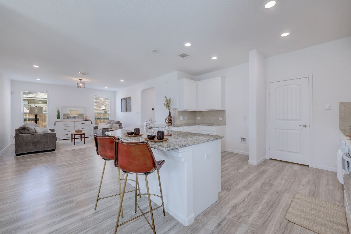 468 Sheepshank Drive Georgetown, TX 78633 - Photo 9 of 27 a kitchen with stainless steel appliances granite countertop a stove a sink a refrigerator and white cabinets with wooden floor
