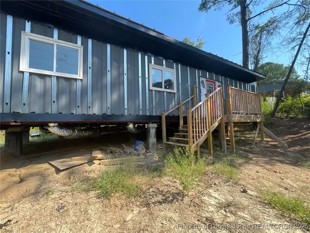 a backyard of a house with large trees and wooden fence