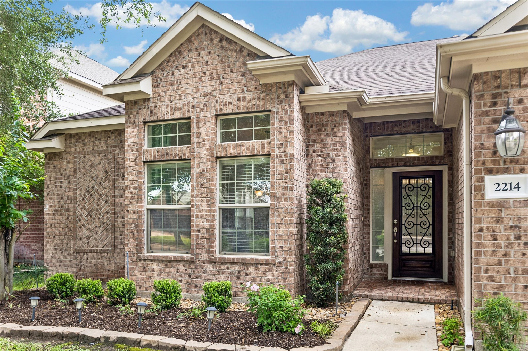2214 Wembley Way Rosenberg, TX 77471 - Photo 6 of 35 Brick facade residence featuring a decorative entryway with wrought iron detailing, arched transom window, and a side light