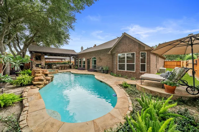 a view of a house with pool fire pit and chairs in patio