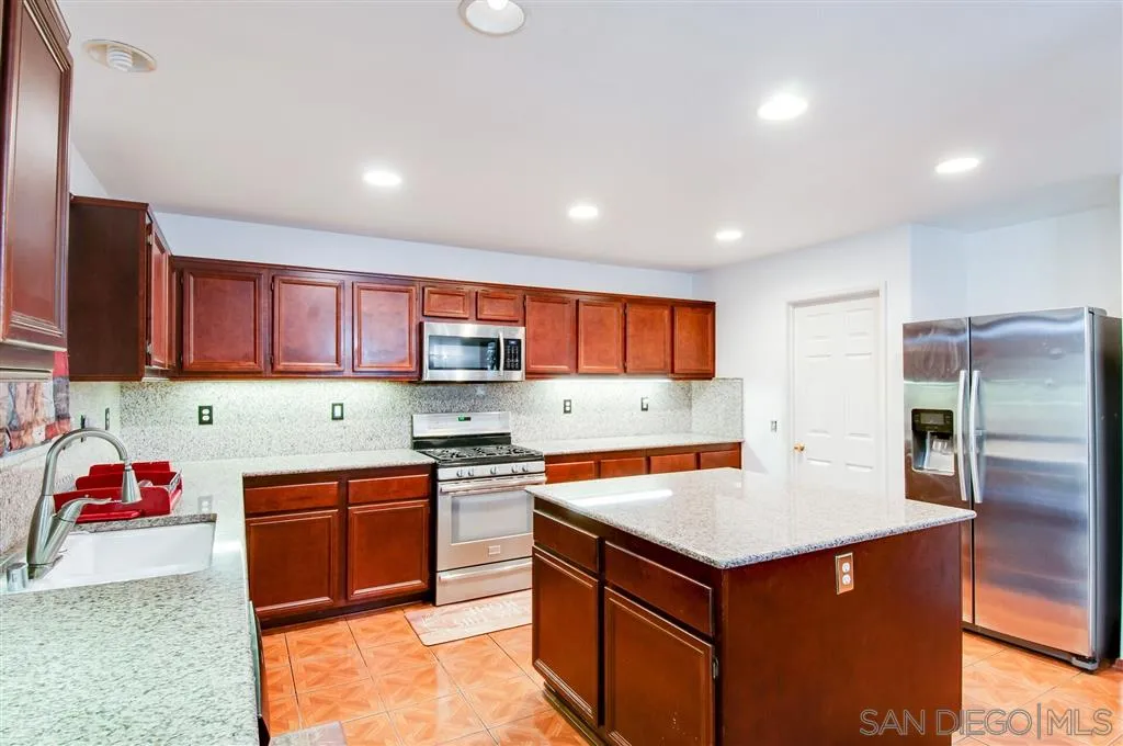 38305 Encanto Road Murrieta, CA 92563 - Photo 18 of 24 a kitchen with stainless steel appliances granite countertop a sink stove and refrigerator
