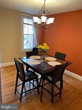 a dining room with furniture a chandelier and wooden floor