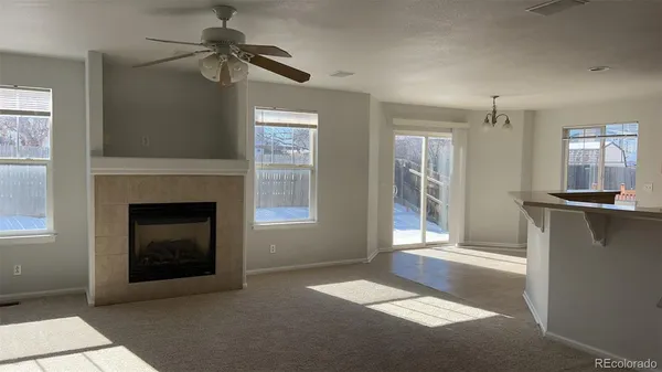 a view of an empty room with a fireplace and a window