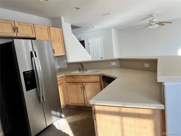 a kitchen that has a sink a refrigerator and a stove top oven