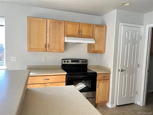 a kitchen with wooden cabinets and a stove top oven