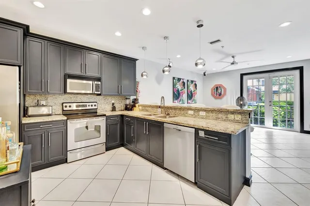 a kitchen with stainless steel appliances granite countertop a stove and cabinets