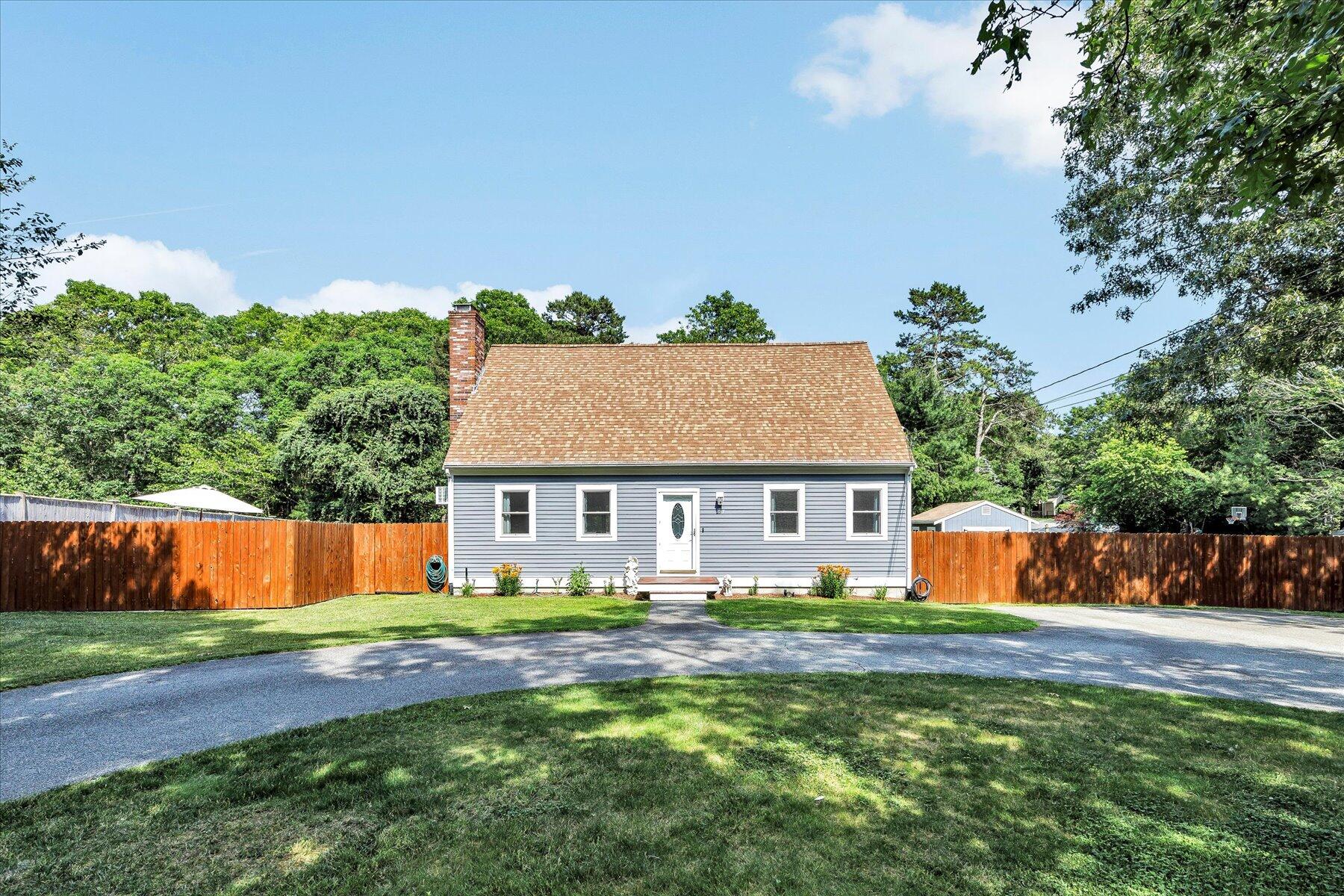 127 South Sandwich Road Mashpee, MA 02649 - Photo 4 of 55 a front view of house with yard and trees in the background