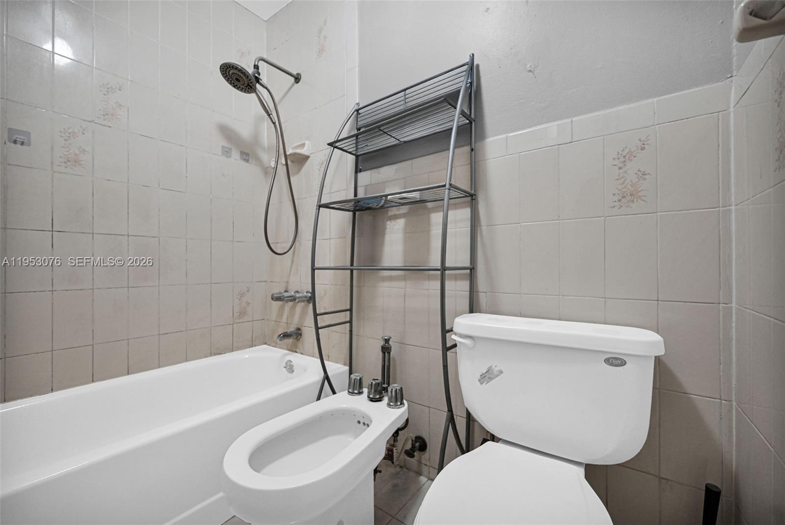 14837 Southwest 60th Street Miami, FL 33193 - Photo 15 of 21 a white toilet sitting next to a bath tub and a shower