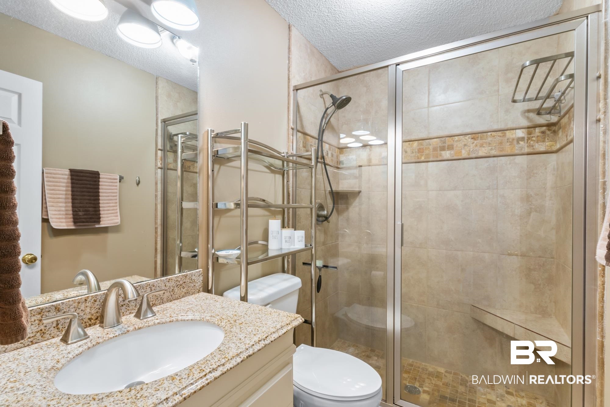 328 Windmill Ridge Road Gulf Shores, AL 36542 - Photo 16 of 47 Bathroom with vanity, a textured ceiling, toilet, and a shower with door