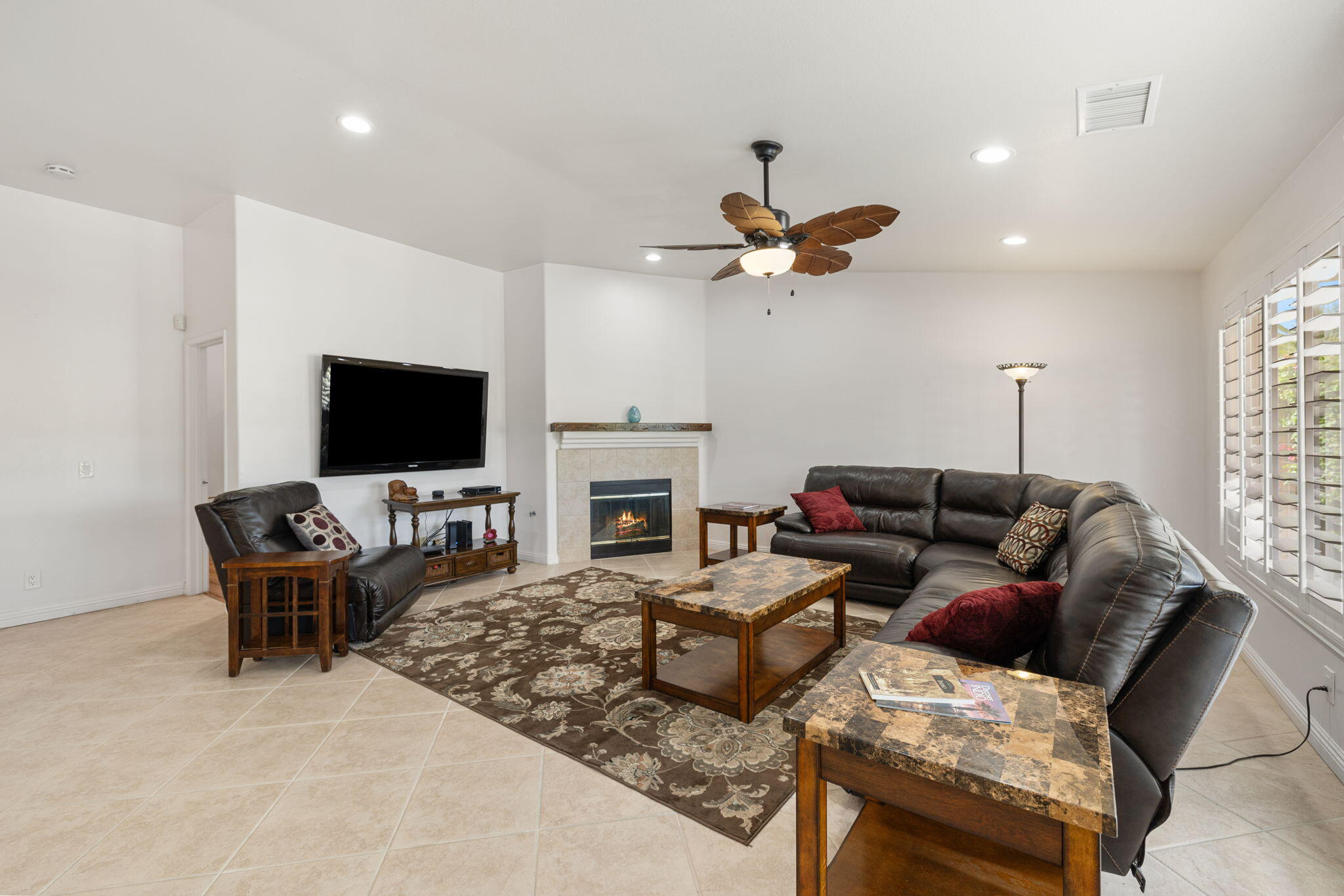 82420 Astaire Avenue Indio, CA 92201 - Photo 11 of 61 a living room with furniture a fireplace and a flat screen tv