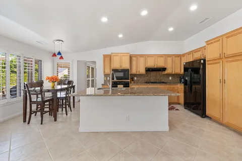 a view of kitchen with refrigerator stove dining table and chairs