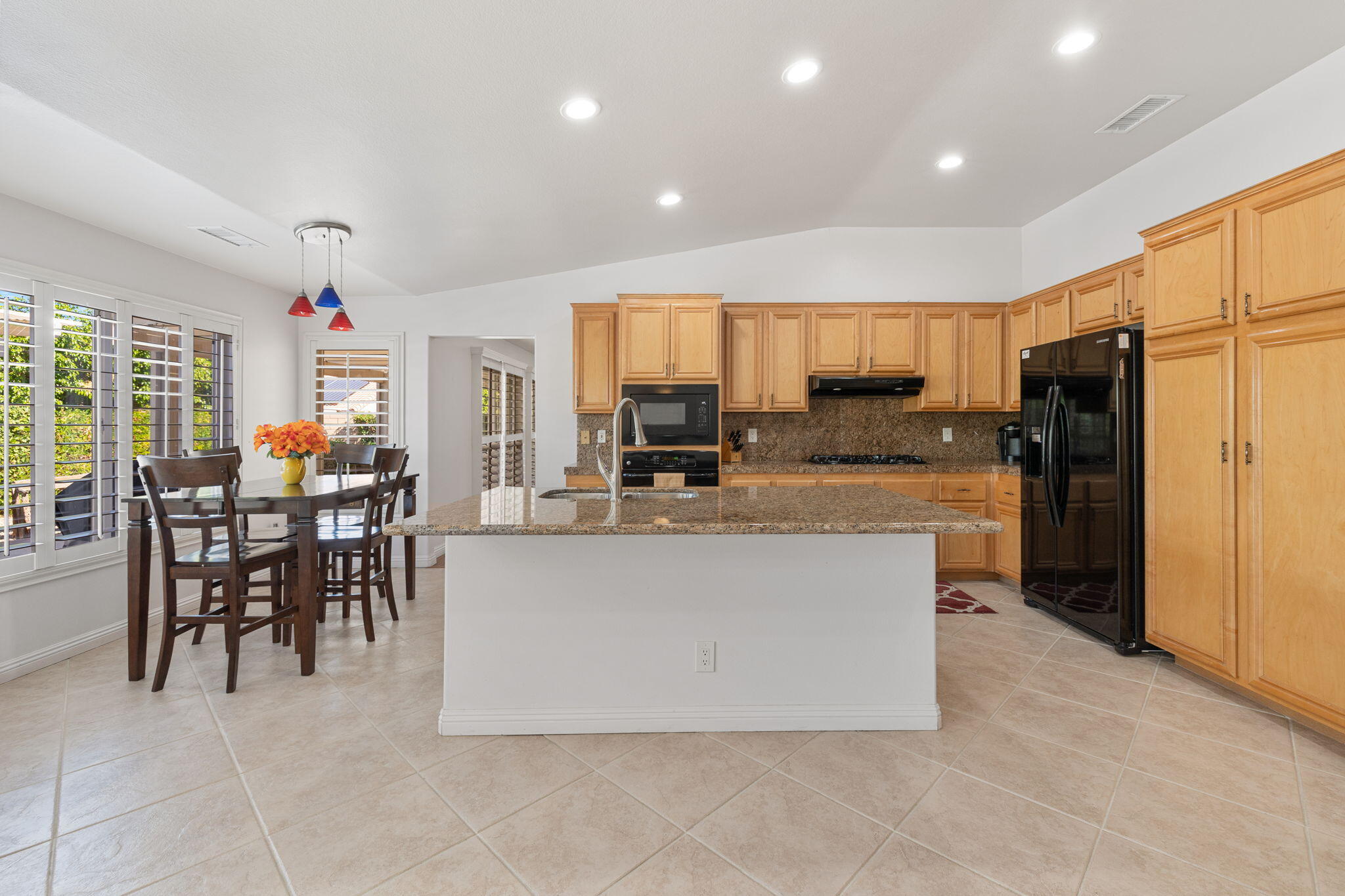 82420 Astaire Avenue Indio, CA 92201 - Photo 14 of 61 a view of kitchen with refrigerator stove dining table and chairs