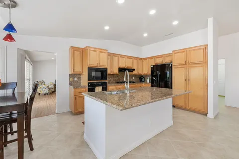 a kitchen with stainless steel appliances granite countertop a sink a stove and a refrigerator