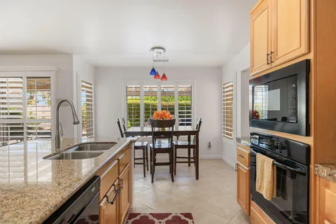 a kitchen with granite countertop a sink stove and cabinets