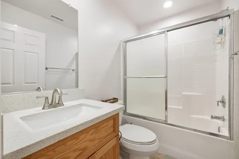 a large bed sitting in a bedroom next to a window and a chair