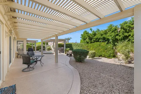 a patio with a table and chairs and potted plants