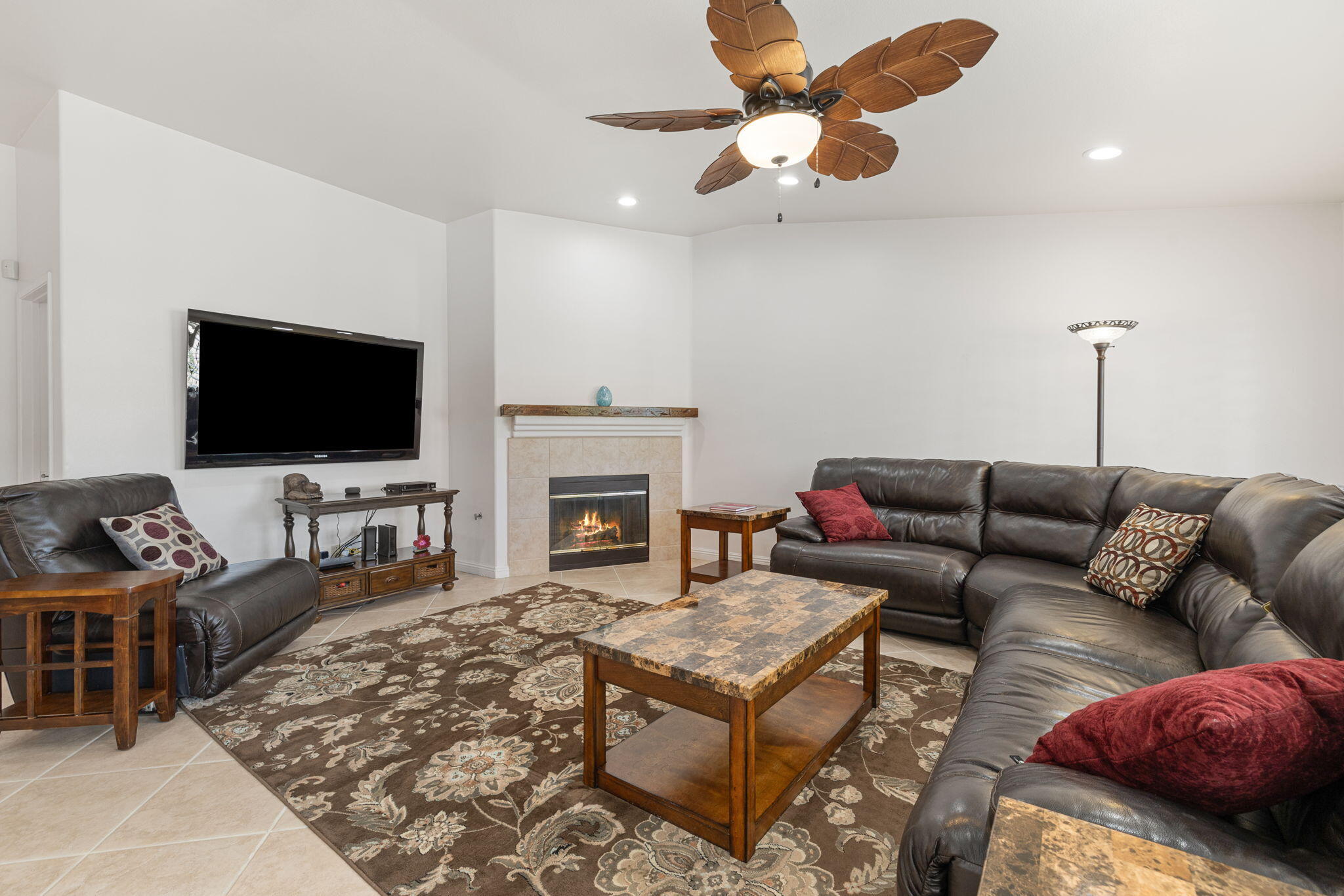 82420 Astaire Avenue Indio, CA 92201 - Photo 9 of 61 a living room with furniture a flat screen tv and a fireplace