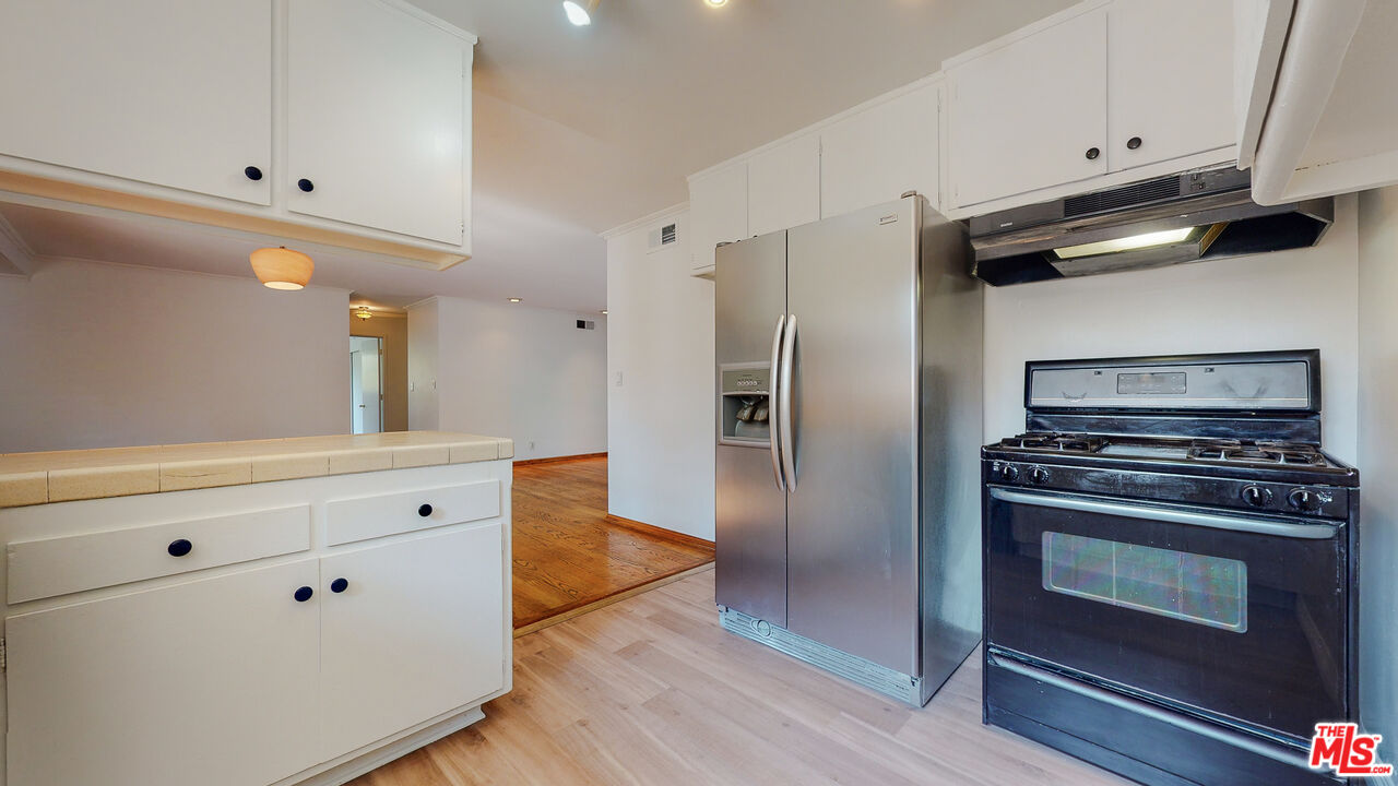 4535 El Prieto Road Altadena, CA 91001 - Photo 19 of 41 a kitchen with white cabinets and stainless steel appliances