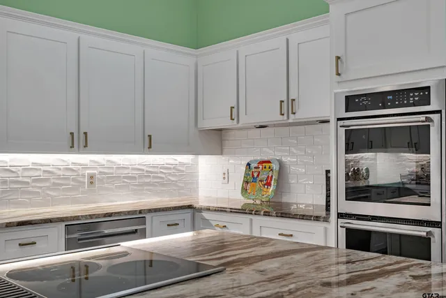 a kitchen with stainless steel appliances granite countertop a stove and a refrigerator