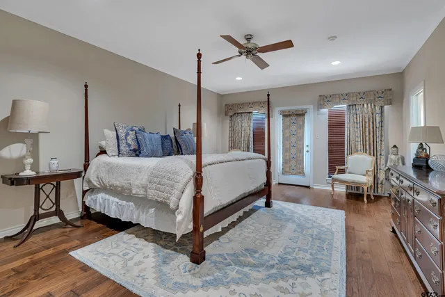 a bedroom with a bed a table and painting on the wall