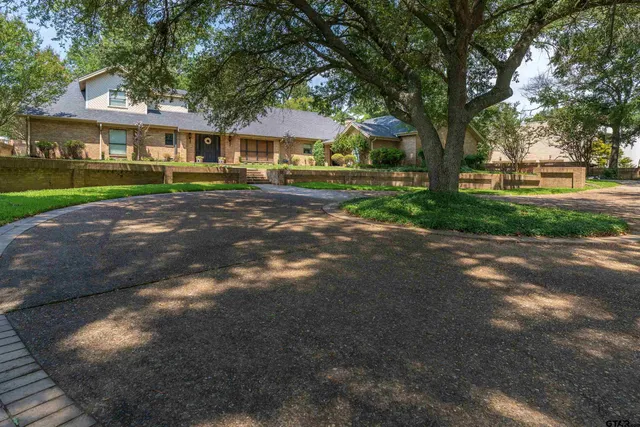 a front view of a house with a yard and green space