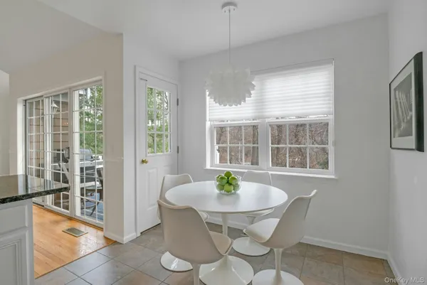 a kitchen with stainless steel appliances a white cabinets counter space and a view of living room