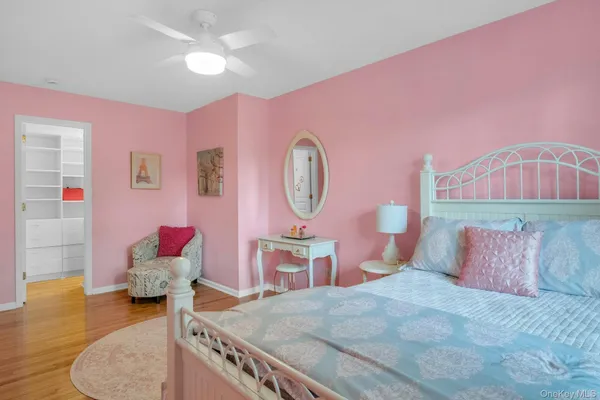 a bedroom with a large window and wooden floor